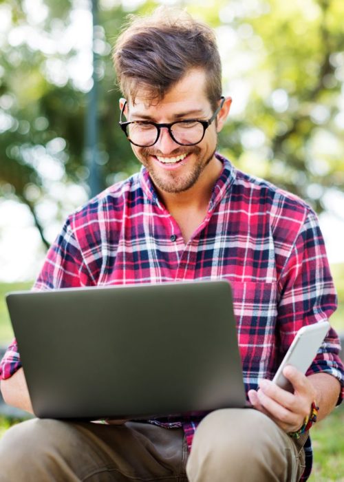 young-man-smartphone-browsing-laptop-concept-2023-11-27-04-59-31-utc.jpg